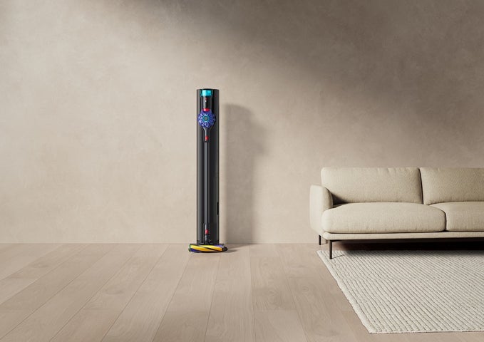 室内で黒い自動ゴミ収集ドックに収納されたDyson V10 Opticの製品写真